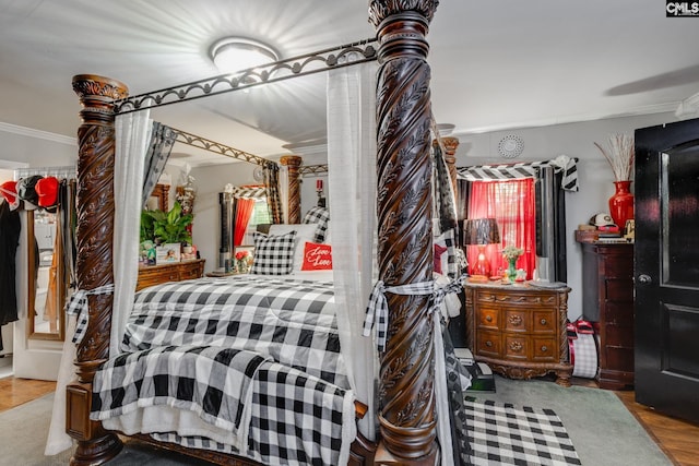 bedroom with wood finished floors and crown molding