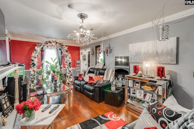 living area with ornamental molding, a chandelier, and wood finished floors