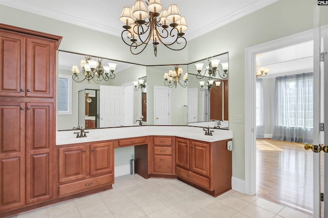 bathroom with a sink, an inviting chandelier, double vanity, and crown molding