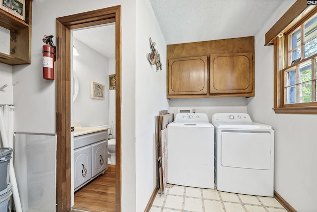 320 Brookshire Dr, Columbia, SC 29210 - washroom with light floors, baseboards, washer and dryer, cabinet space, and a textured ceiling