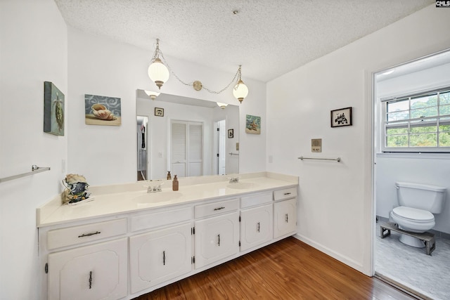 320 Brookshire Dr, Columbia, SC 29210 - full bath featuring wood finished floors, a sink, double vanity, and a textured ceiling