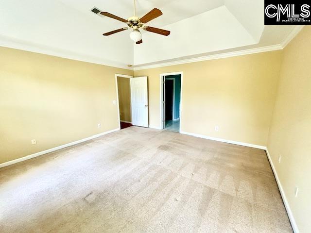 unfurnished bedroom with vaulted ceiling, visible vents, crown molding, baseboards, and light colored carpet