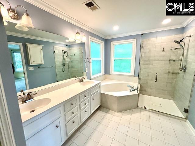 bathroom featuring a bath, tile patterned floors, a sink, and visible vents