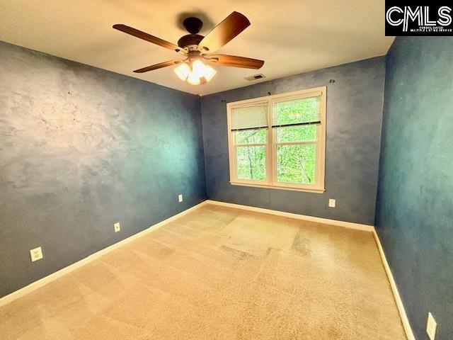 unfurnished room featuring baseboards, a ceiling fan, visible vents, and carpet floors