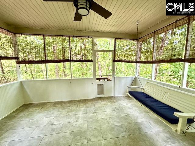 unfurnished sunroom featuring ceiling fan