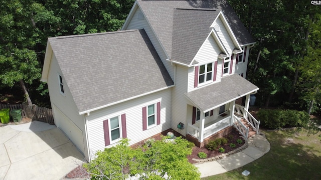 exterior space featuring covered porch, fence, and a shingled roof