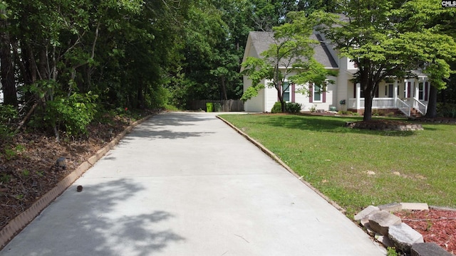view of front of house featuring driveway, fence, and a front yard