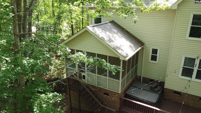 rear view of house with stairway, a shingled roof, a sunroom, and crawl space