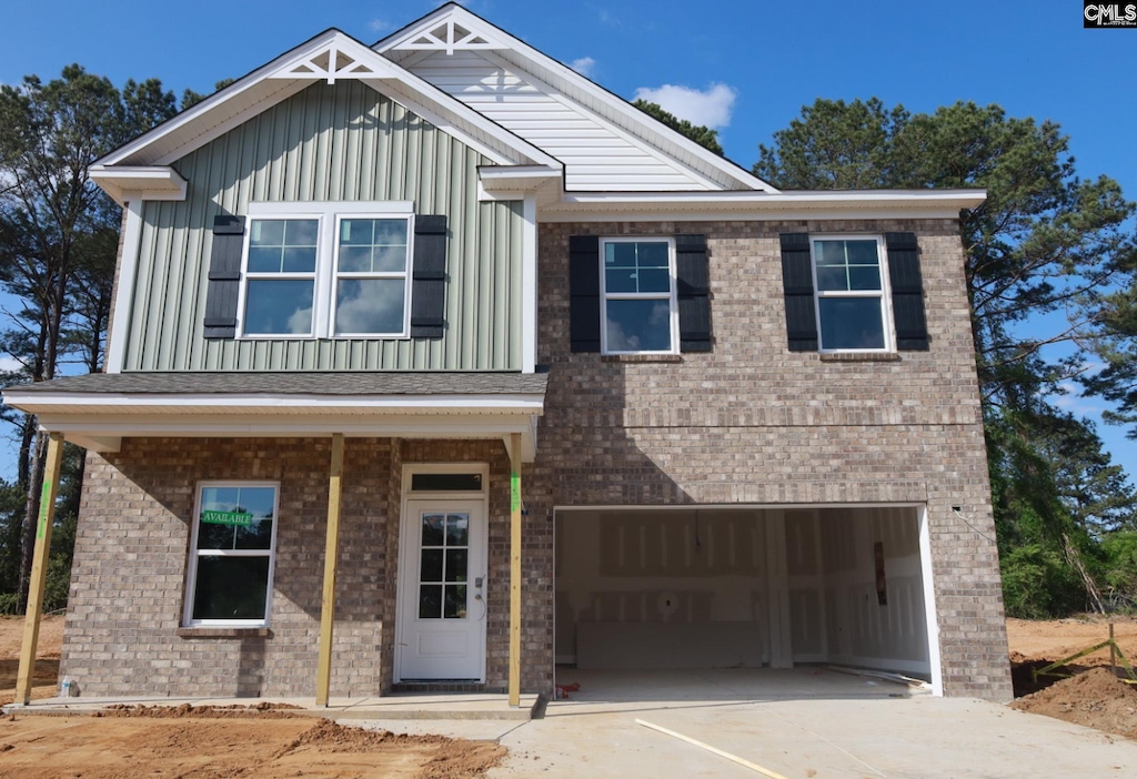 craftsman-style house featuring board and batten siding, an attached garage, brick siding, and concrete driveway