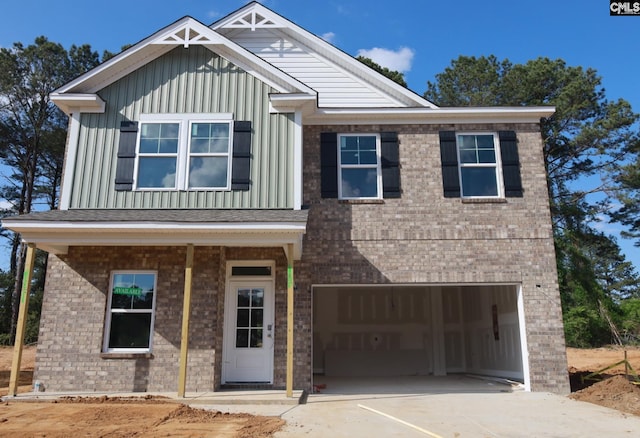 craftsman-style house featuring board and batten siding, an attached garage, brick siding, and concrete driveway