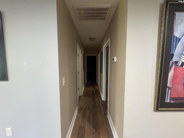 corridor featuring attic access, baseboards, hardwood / wood-style floors, and visible vents