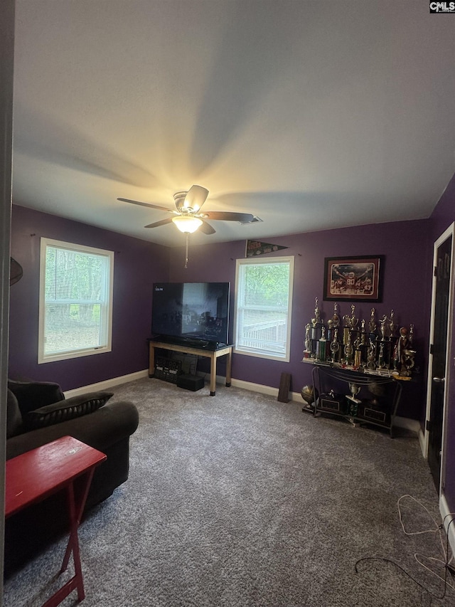 carpeted living area featuring ceiling fan, a wealth of natural light, and baseboards