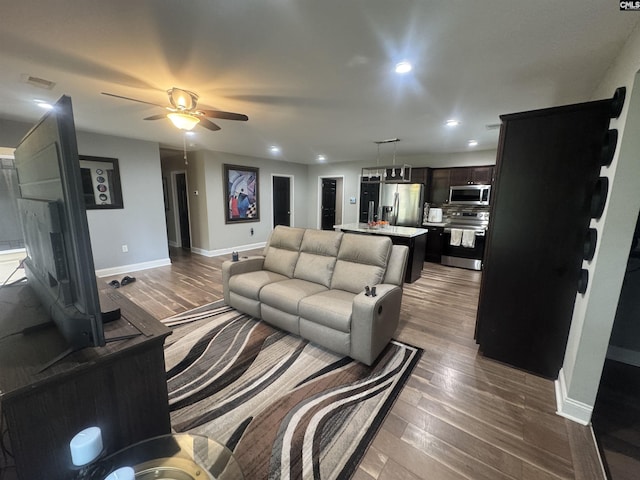 living room featuring visible vents, baseboards, recessed lighting, ceiling fan, and dark wood-type flooring
