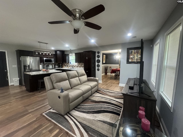 living area featuring ceiling fan, baseboards, wood finished floors, and recessed lighting