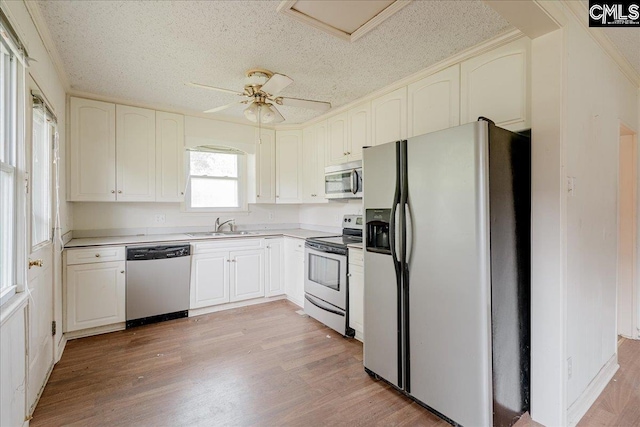 143 Indian Cove Rd, Chapin, SC 29036 - kitchen featuring a textured ceiling, a sink, stainless steel appliances, light wood finished floors, and light countertops