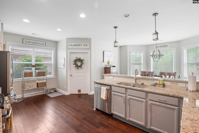 kitchen featuring stainless steel dishwasher, a sink, pendant lighting, dark wood finished floors, and gray cabinetry