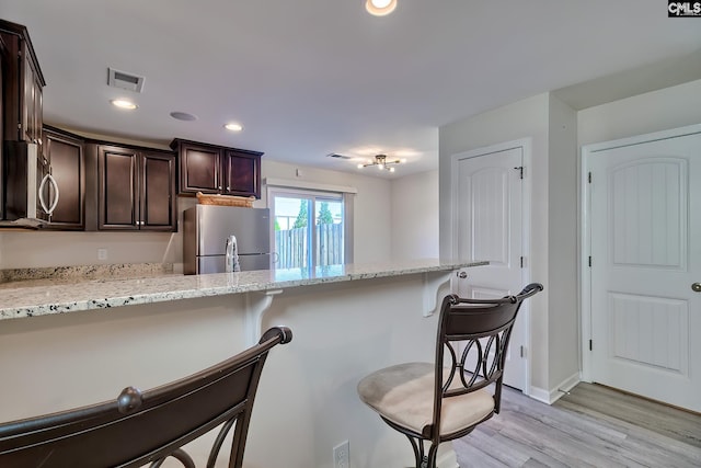 258 Gum Swamp Trl, West Columbia, SC 29169 - kitchen featuring a breakfast bar, visible vents, dark brown cabinetry, light wood-style flooring, and appliances with stainless steel finishes