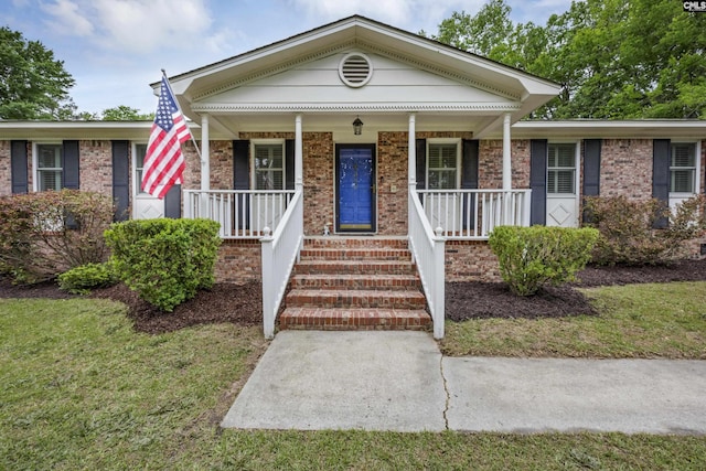 view of front facade featuring brick siding and a porch