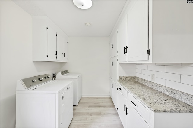 washroom with separate washer and dryer, baseboards, light wood-style floors, and cabinet space