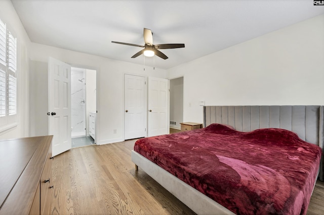 bedroom featuring wood finished floors, visible vents, a ceiling fan, and connected bathroom