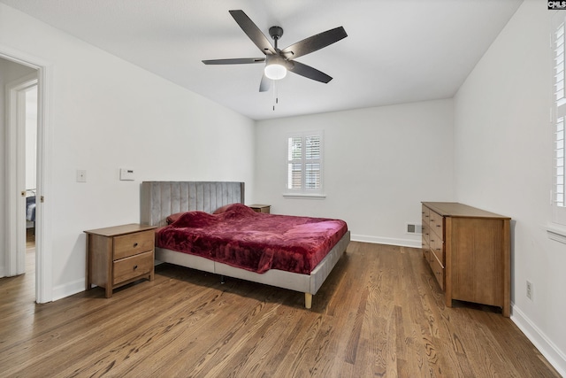 bedroom with ceiling fan, baseboards, wood finished floors, and visible vents