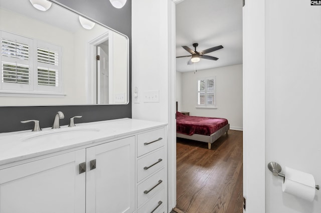 bathroom featuring baseboards, wood finished floors, vanity, and ceiling fan
