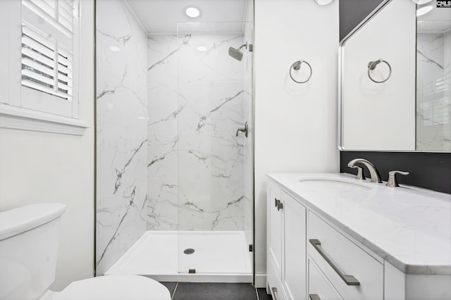 bathroom featuring toilet, vanity, and a marble finish shower