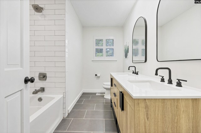 bathroom featuring toilet, tile patterned flooring, a sink, and baseboards