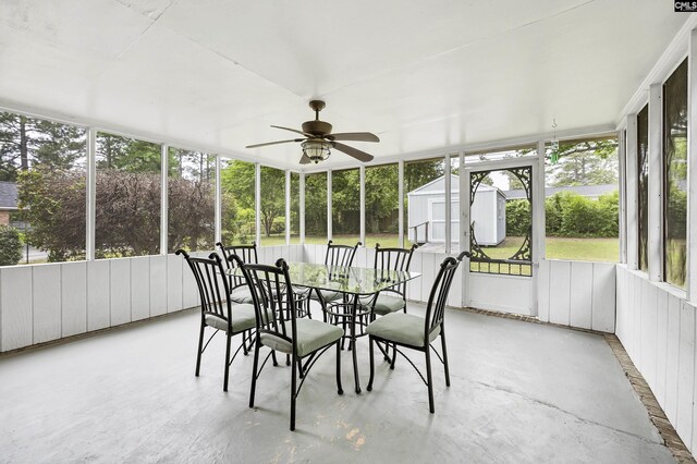 sunroom with a ceiling fan, outdoor dining space, and plenty of natural light