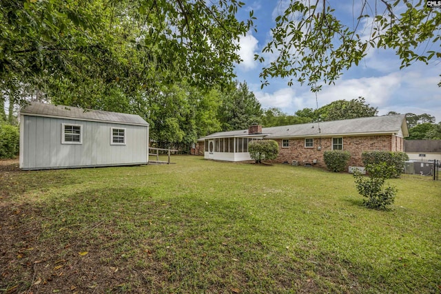 view of yard with a sunroom, an outbuilding, and fence