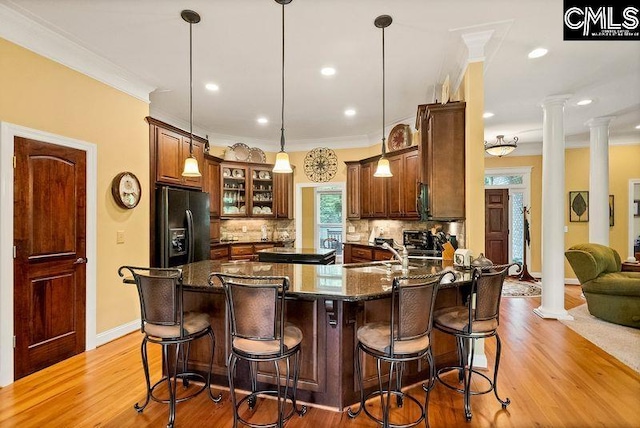 1437 Heins Rd, Blythewood, SC 29016 - kitchen with black fridge with ice dispenser, a sink, backsplash, and ornate columns