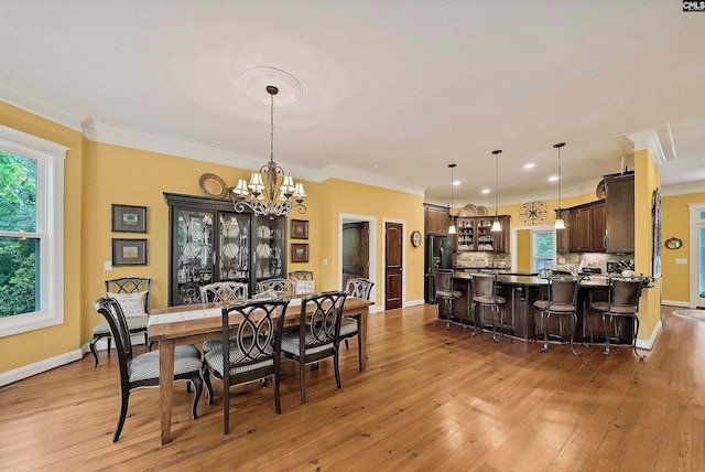 1437 Heins Rd, Blythewood, SC 29016 - dining space with a chandelier, crown molding, and light wood finished floors