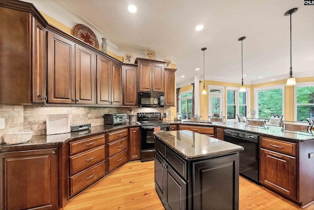 1437 Heins Rd, Blythewood, SC 29016 - kitchen featuring crown molding, a center island, black appliances, a peninsula, and light wood-style flooring