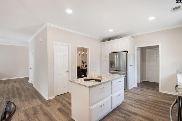 kitchen with crown molding, stainless steel refrigerator with ice dispenser, white cabinetry, dark wood-type flooring, and visible vents
