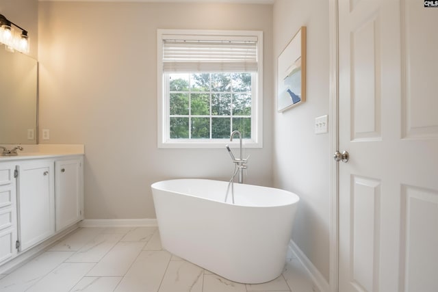 bathroom featuring baseboards, a freestanding tub, marble finish floor, and vanity