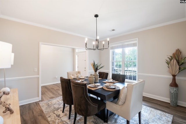 dining area with wood finished floors, visible vents, crown molding, baseboards, and a chandelier