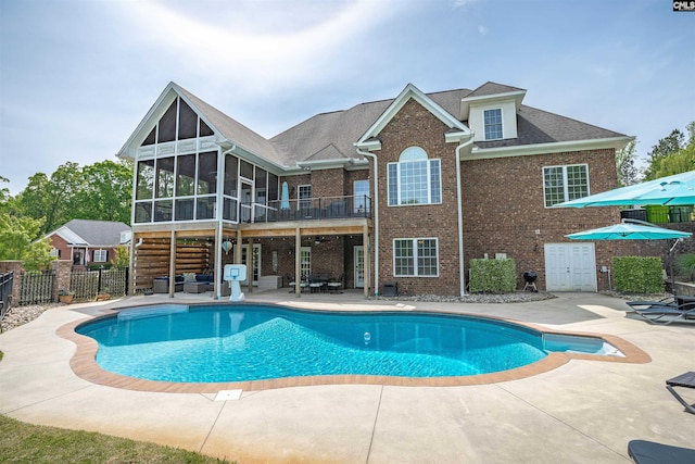 view of pool with a fenced in pool, fence, a sunroom, and a patio area