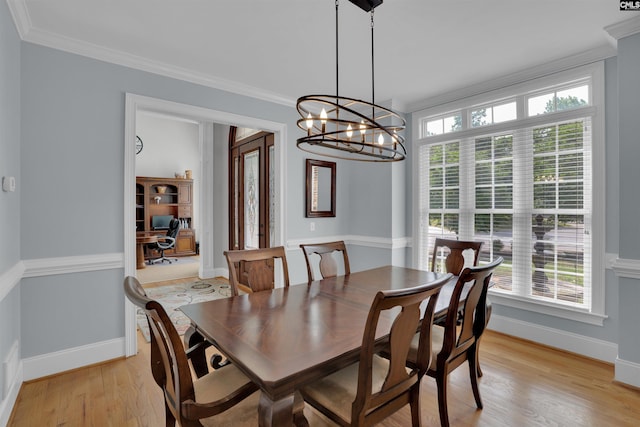 dining room featuring crown molding, light wood-type flooring, an inviting chandelier, and plenty of natural light