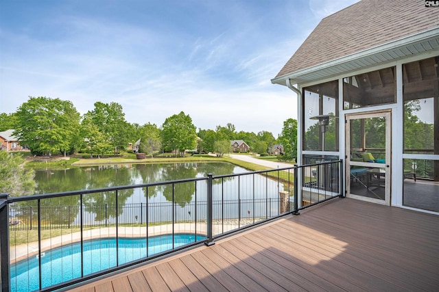 deck with fence, a water view, a sunroom, and a fenced in pool