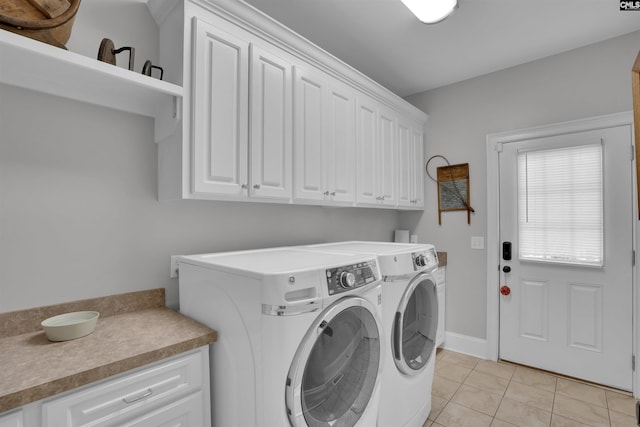 washroom with separate washer and dryer, cabinet space, and light tile patterned flooring