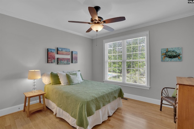 bedroom featuring baseboards, light wood-style floors, and crown molding
