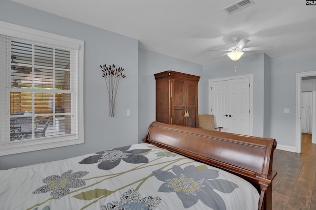 bedroom featuring visible vents, a ceiling fan, dark wood-style floors, and baseboards