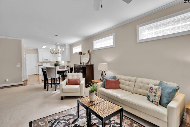 living area featuring ornamental molding, baseboards, and ceiling fan with notable chandelier