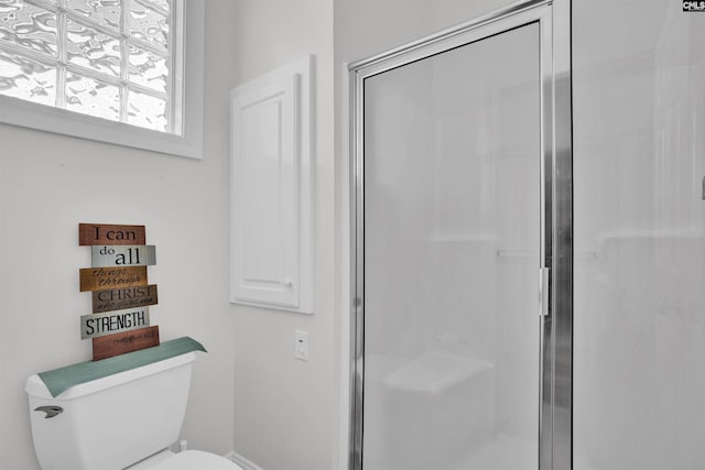 full bathroom featuring toilet, a stall shower, and baseboards