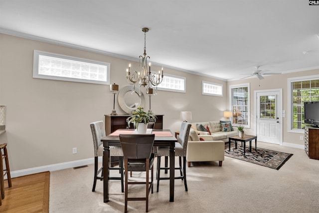 dining area featuring light colored carpet, visible vents, crown molding, and baseboards