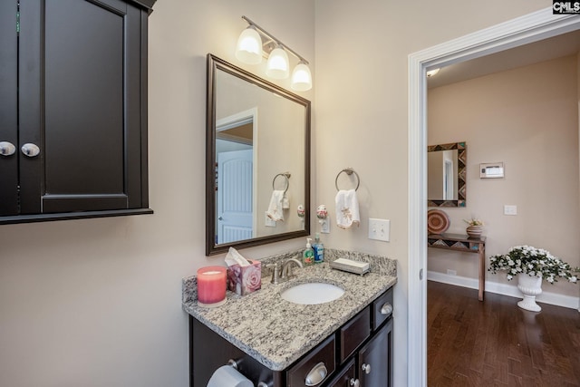 bathroom with baseboards, wood finished floors, and vanity