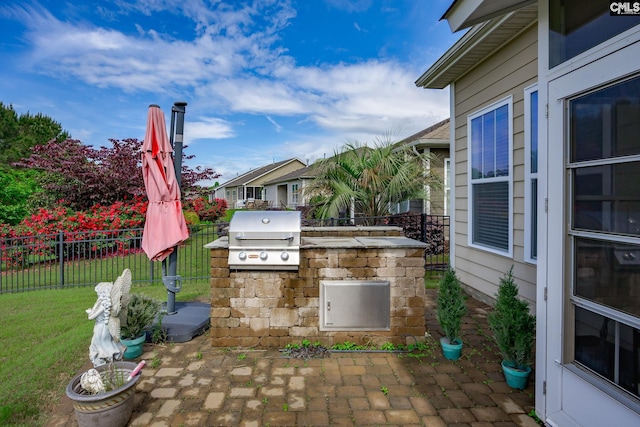 view of patio featuring exterior kitchen, grilling area, and fence
