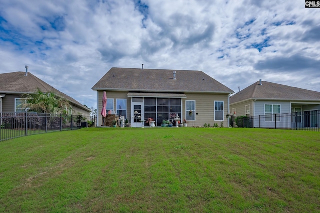 back of property featuring a yard, a fenced backyard, and a sunroom