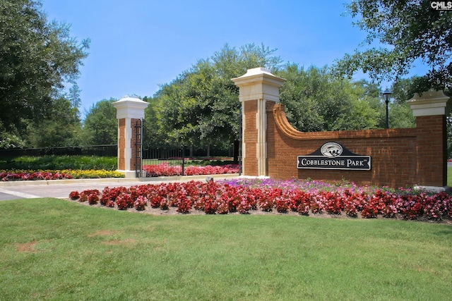 community / neighborhood sign featuring a yard