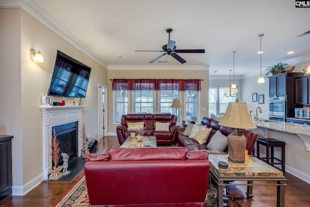 living area featuring baseboards, ornamental molding, and a ceiling fan